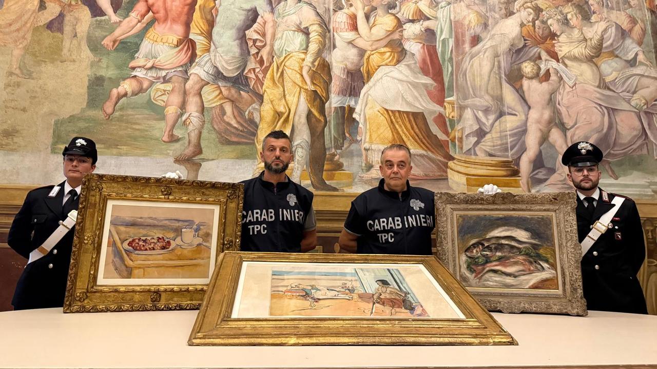Vier italienische Polizisten posieren mit drei Gemälden von Cezanne, Matisse und Renoir vor einem großen Wandgemälde.