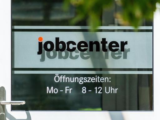 An der Eingangstür eines Jobcenters stehen die Öffnungszeiten: Montag bis Freitag von 8 bis 12 Uhr, Termine außerhalb dieser Zeiten nach Vereinbarung möglich.