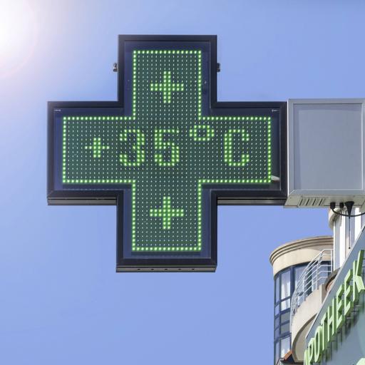 Auf dem kreuzförmigen Schild einer Apotheke zeigt ein Thermometer 35 Grad Celsius an.