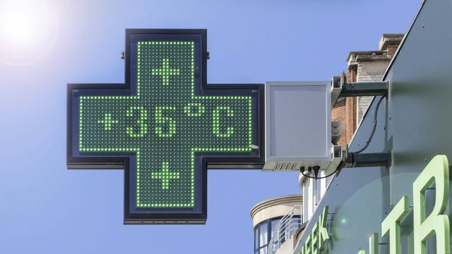 Auf dem kreuzförmigen Schild einer Apotheke zeigt ein Thermometer 35 Grad Celsius an.