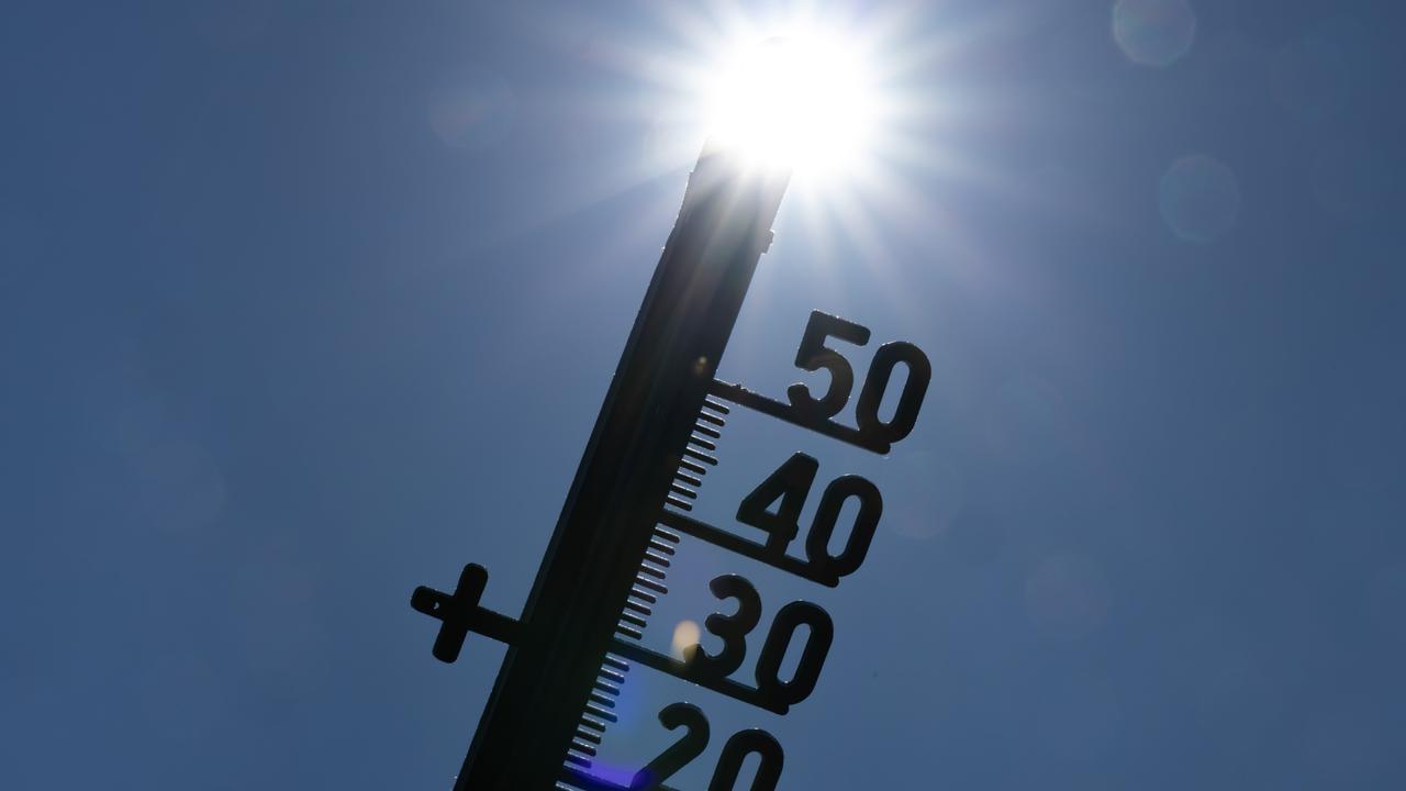 Vor dem Licht der gleißenden Mittagssonne zeichnet sich die Silhouette eines Thermometers ab.