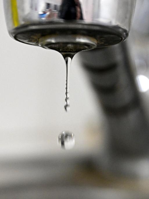 Ein Wassertropfen löst sich aus einem Wasserhahn