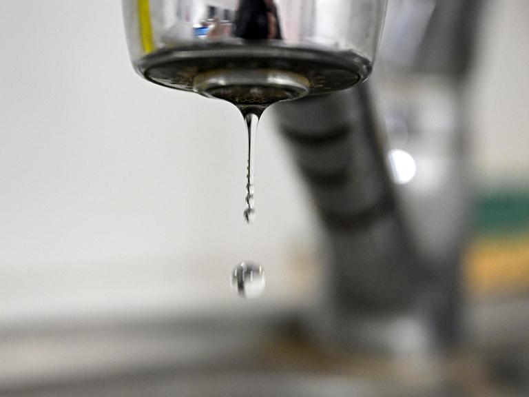 Ein Wassertropfen löst sich aus einem Wasserhahn