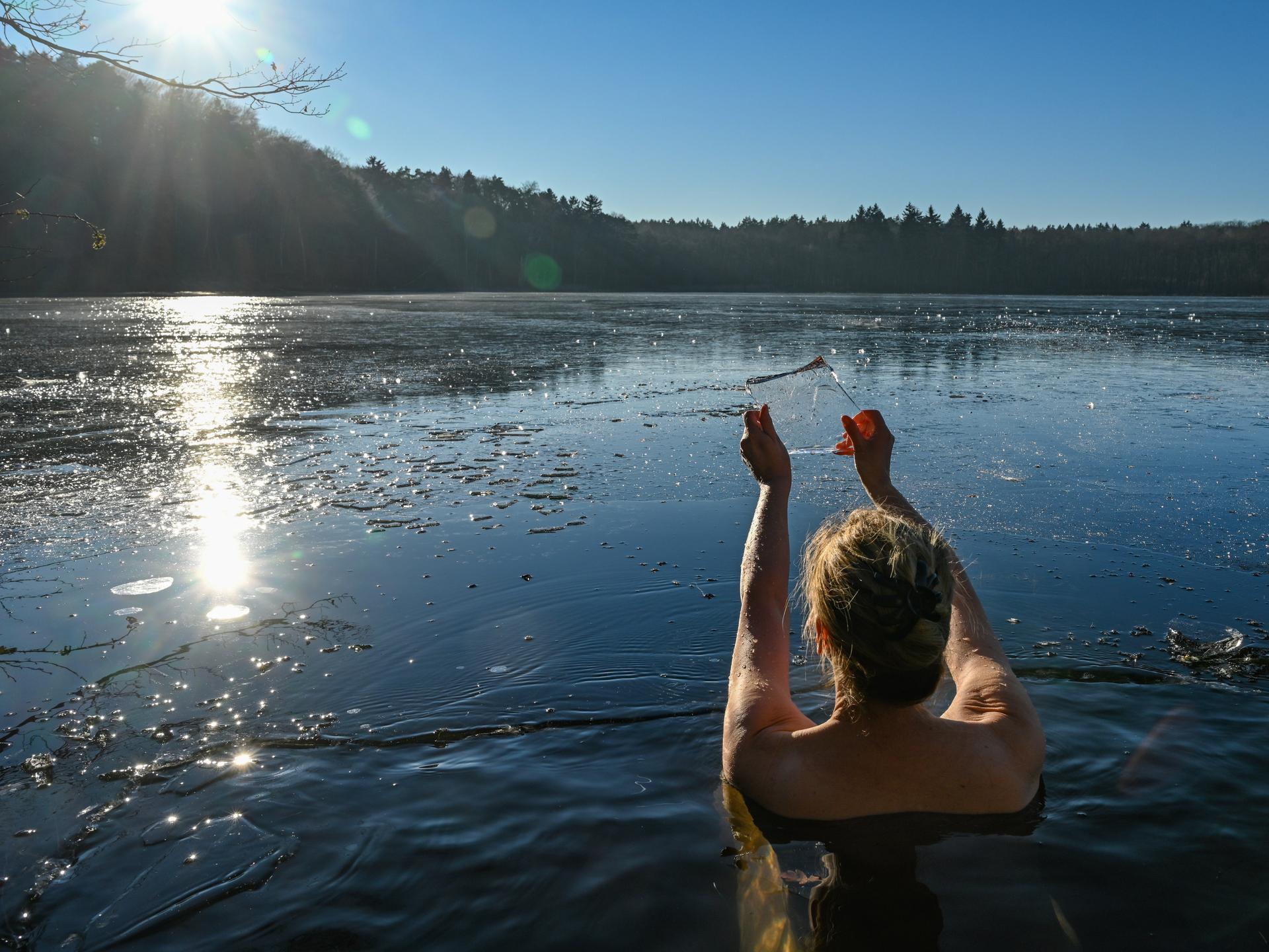 Eine Frau geht im kalten Wasser des Trepliner Sees baden.