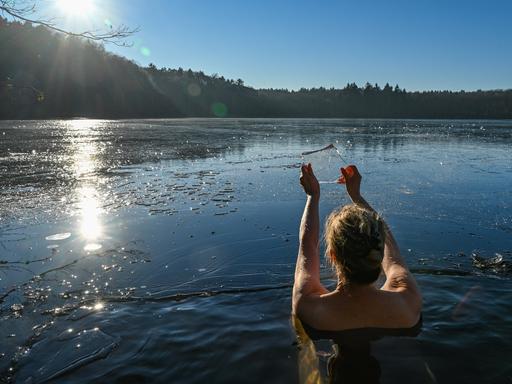 Eine Frau geht im kalten Wasser des Trepliner Sees baden.