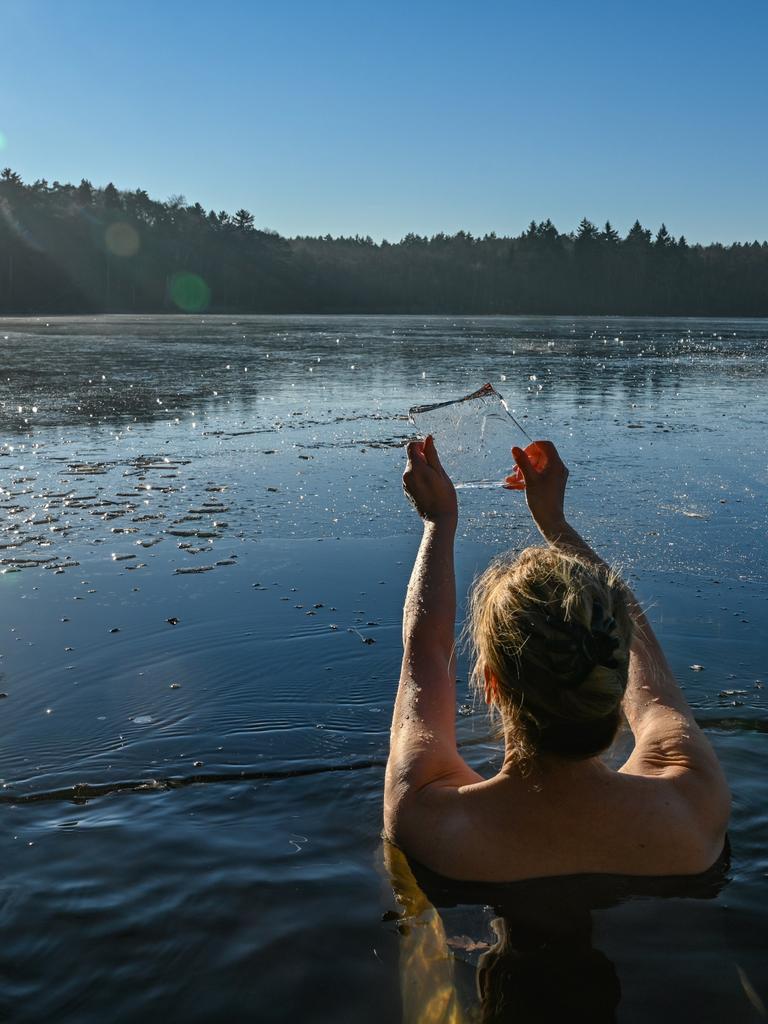 Eine Frau geht im kalten Wasser des Trepliner Sees baden.