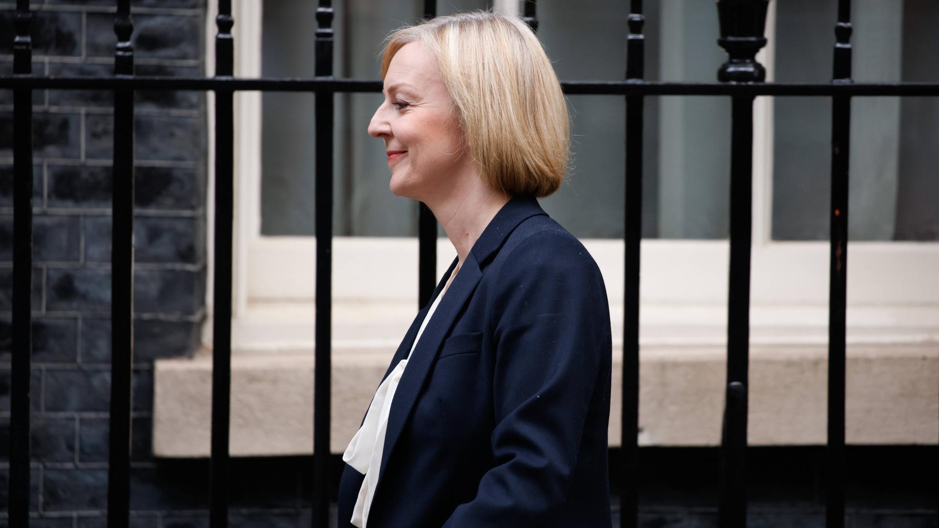 Liz Truss geht an Gitterstäben vorbei. Liz Truss geht an Gitterstäben vorbei.