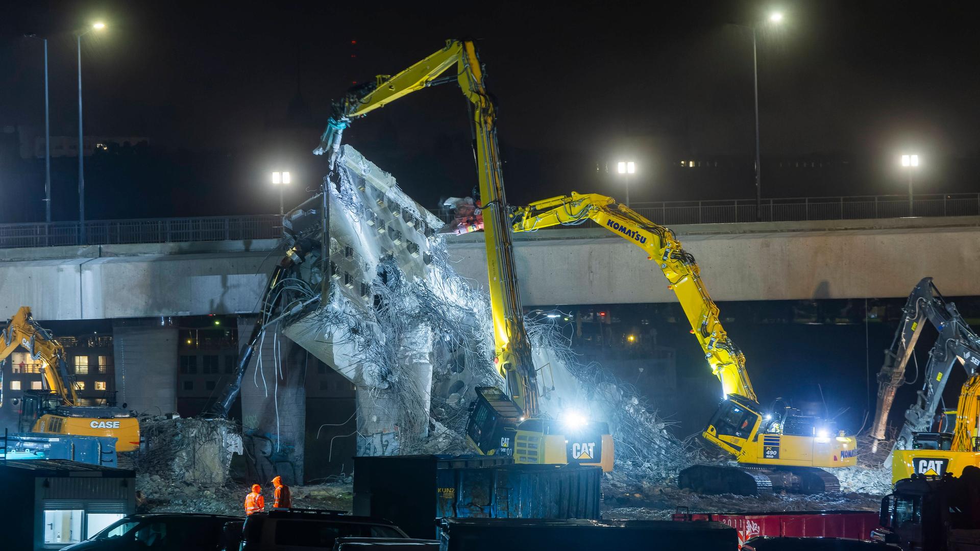 Große Bagger reißen Teile der in Trümmer liegenden Carolabrücke ein.