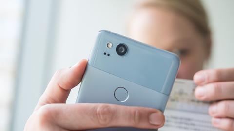 Eine Frau hält am 23.01.2018 in Berlin ein Smartphone und einen Personalausweis in den Haenden, um am Video-Ident-Verfahren teilzunehmen (gestellte Szene). Foto: Andrea Warnecke