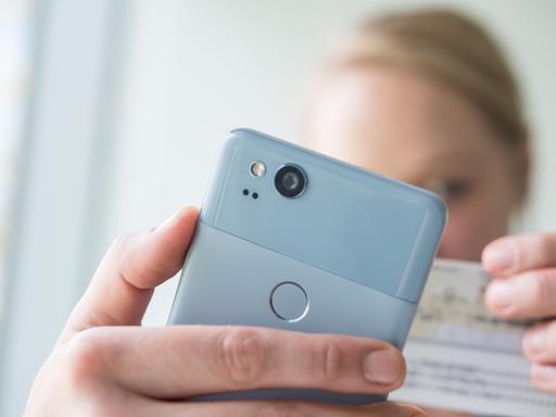 Eine Frau hält am 23.01.2018 in Berlin ein Smartphone und einen Personalausweis in den Haenden, um am Video-Ident-Verfahren teilzunehmen (gestellte Szene). Foto: Andrea Warnecke