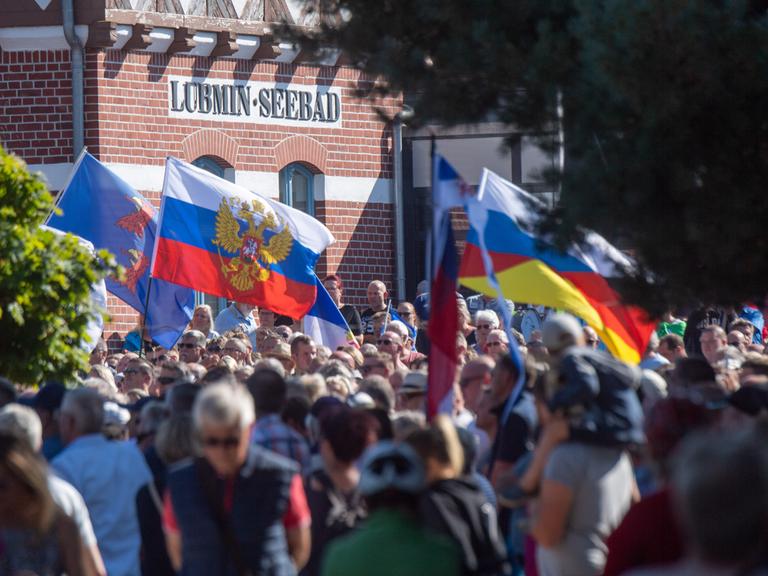 Menschen nehmen an einer Demonstration für die Inbetriebnahme von Nord Stream 2 in Lubmin teil. Der Protest der Demonstration richtete sich erneut auch gegen die Russland-Sanktionen der EU im russischen Angriffskrieg.