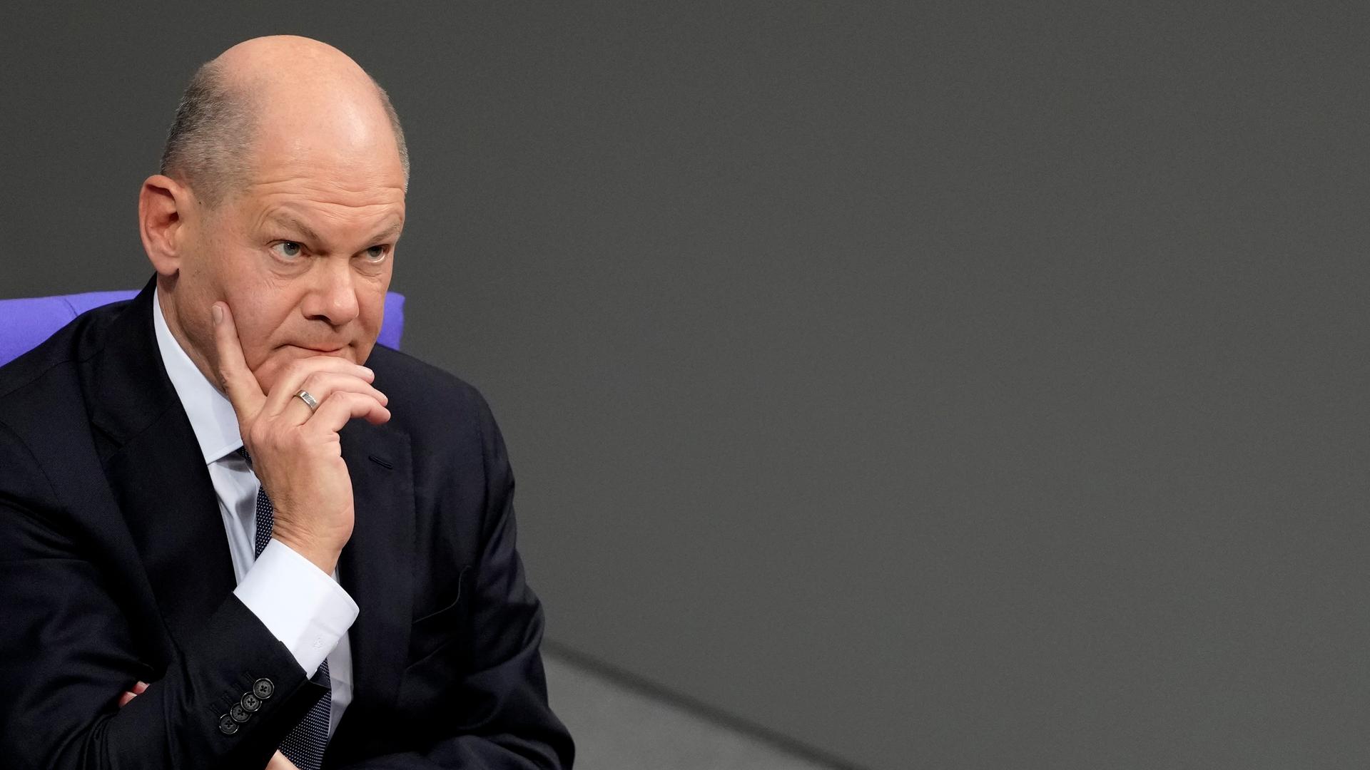 Kanzler Olaf Scholz im Bundestag. Er blickt nachdenklich.