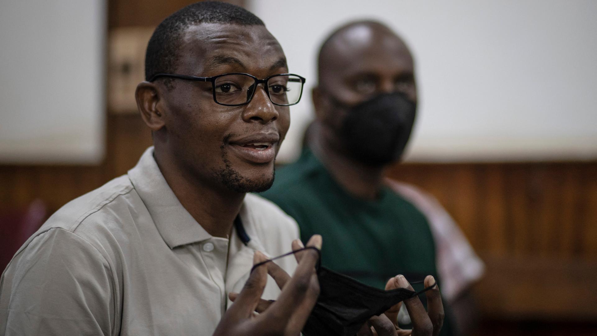 Der afrikanische Autor Kakwenza Rukirabashaija in Ugandas Hauptstadt Kampala. Er hält eine schwarze Mund-Nasen-Maske in den Händen.