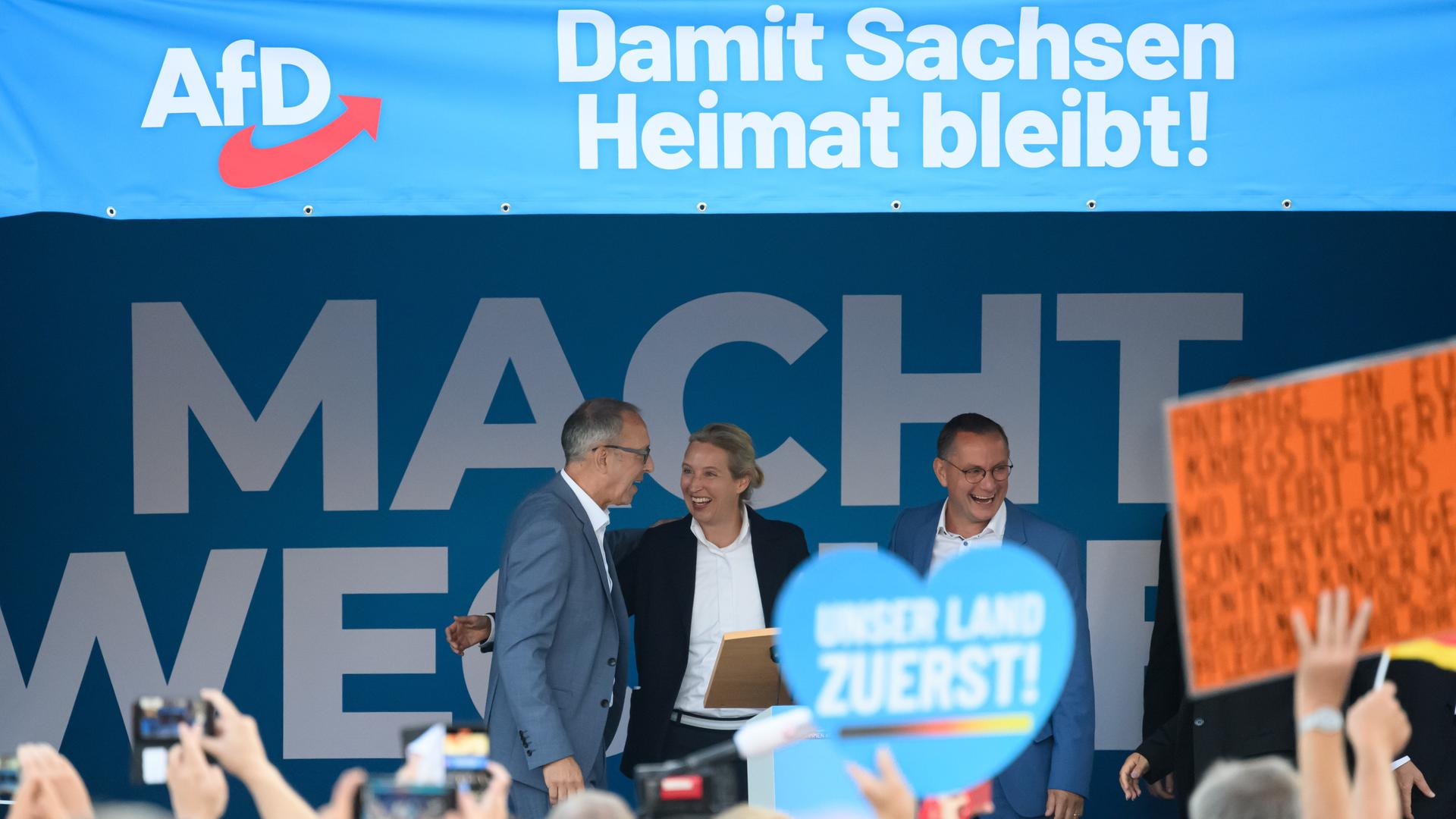 Die AfD-Politiker Jörg Urban, Alice Weidel und Tino Chrupalla stehen bei einer Wahlkampfveranstaltung zur Landtagswahl in Sachsen auf einer Bühne. 