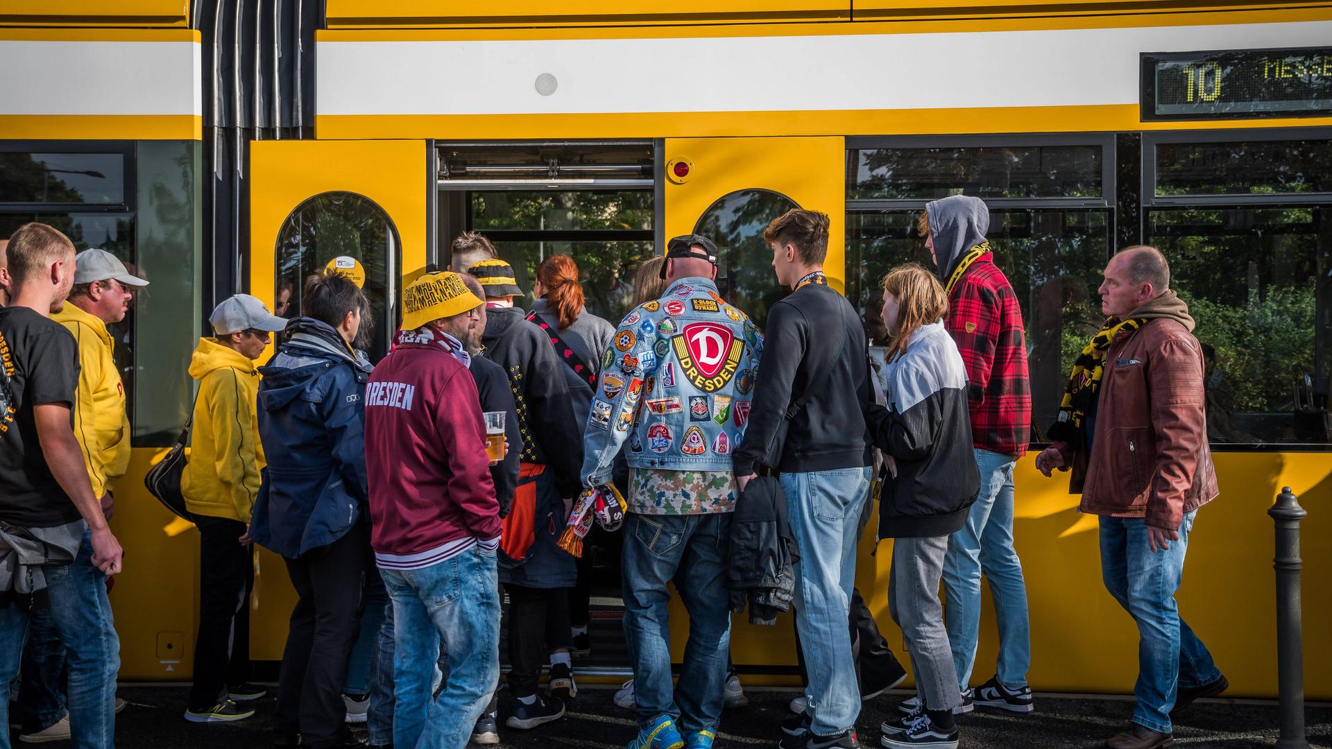 Fans von Dynamo Dresden warten nach einem Spiel an der Haltestelle auf die Bahn. 