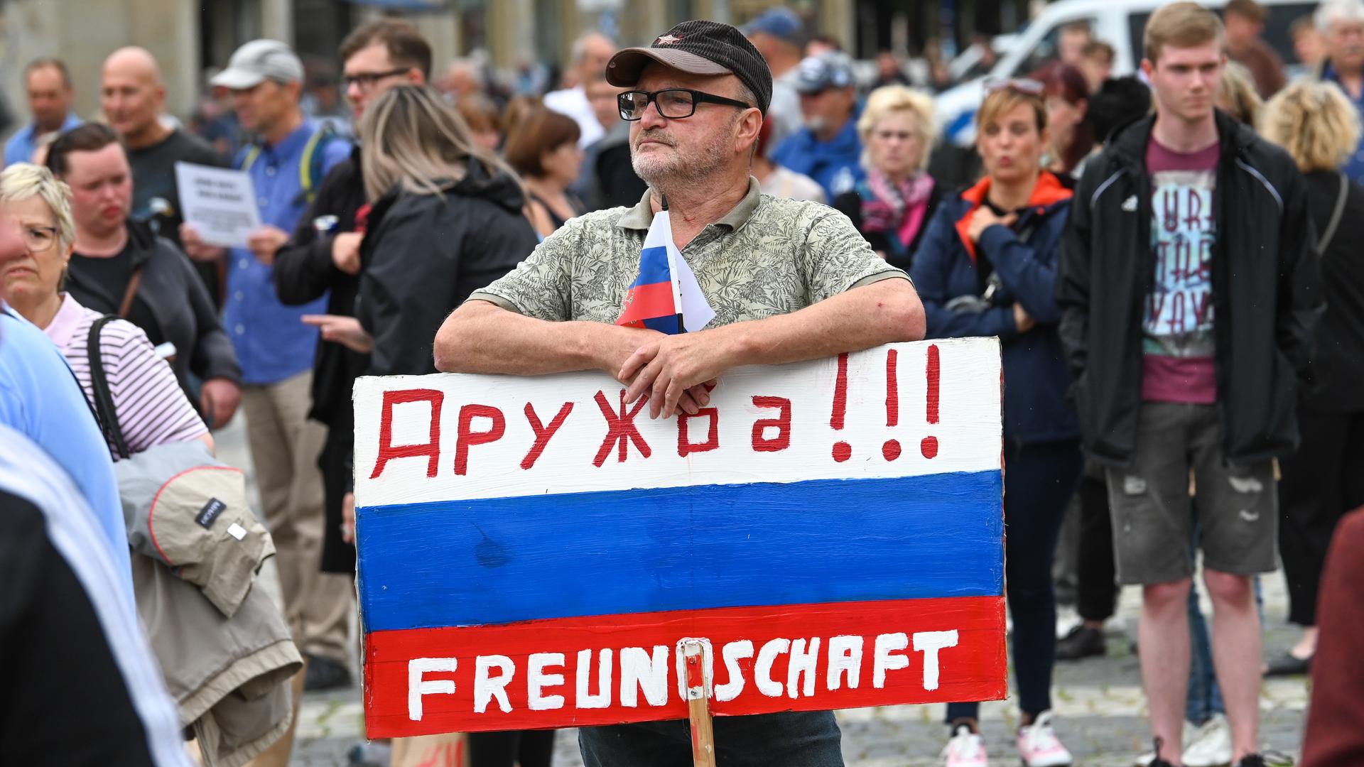 Ein Teilnehmer der AfD-Kundgebung hält ein Schild in den Farben von Russland mit der deutsch-russischen Aufschrift "Druschba!!! - Freundschaft".