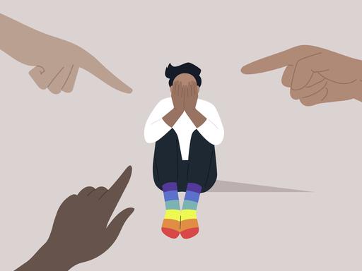 Illustration von Fingern, die aus unterschiedlichen Ecken auf eine LGBTQ Person zeigen, die regenbogenfarbene Socken trägt. Die Person verdeckt ihr Gesicht mit ihren Händen.
