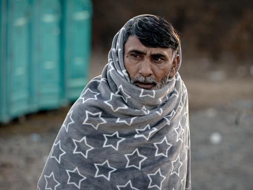 Ein geflüchteter Mann, der in eine Decke gehüllt ist im Camp Lipa an der EU-Außengrenze in Bosnien.