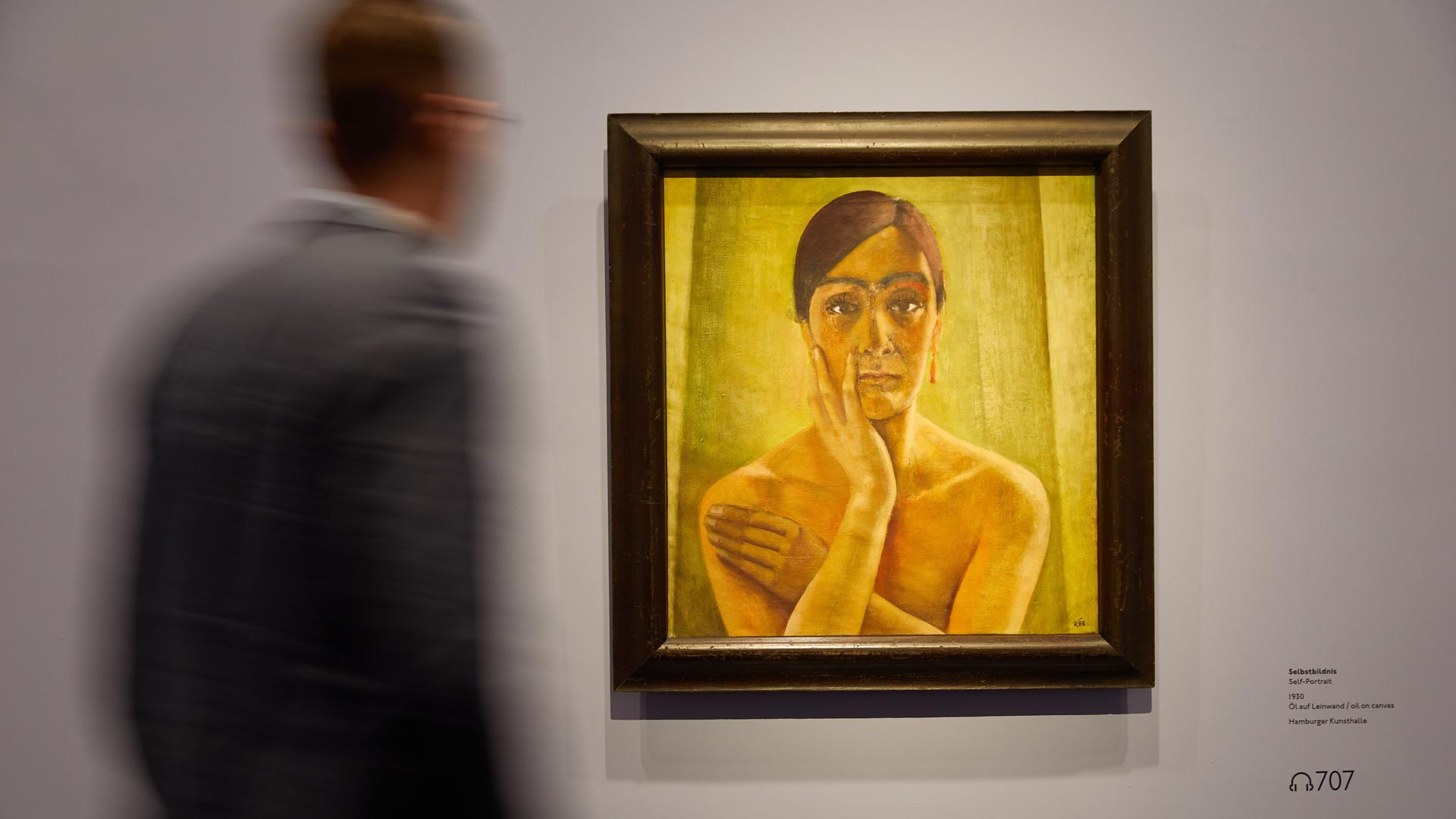 Ein Betrachter steht in der Kunsthalle in Hamburg vor einem gelben Gemälde. Es ist das Bild "Selbstbildnis" der Malerin Anita Rée.