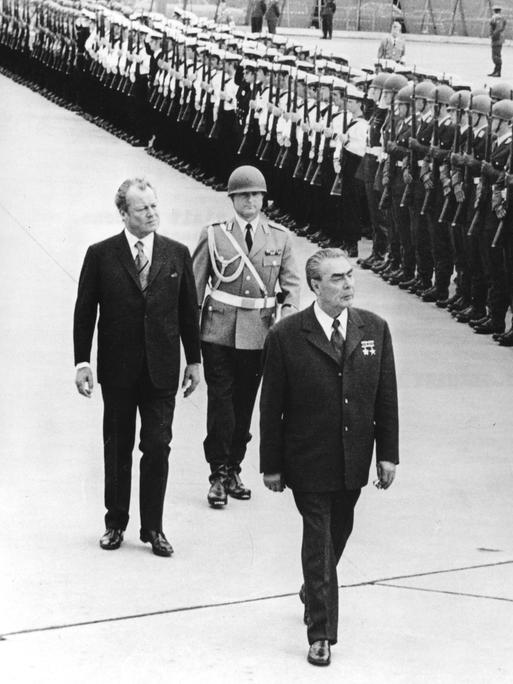 Willy Brandt (l.) und Leonid Breschnew. Zwei ältere Männer laufen eine Militärparade ab.