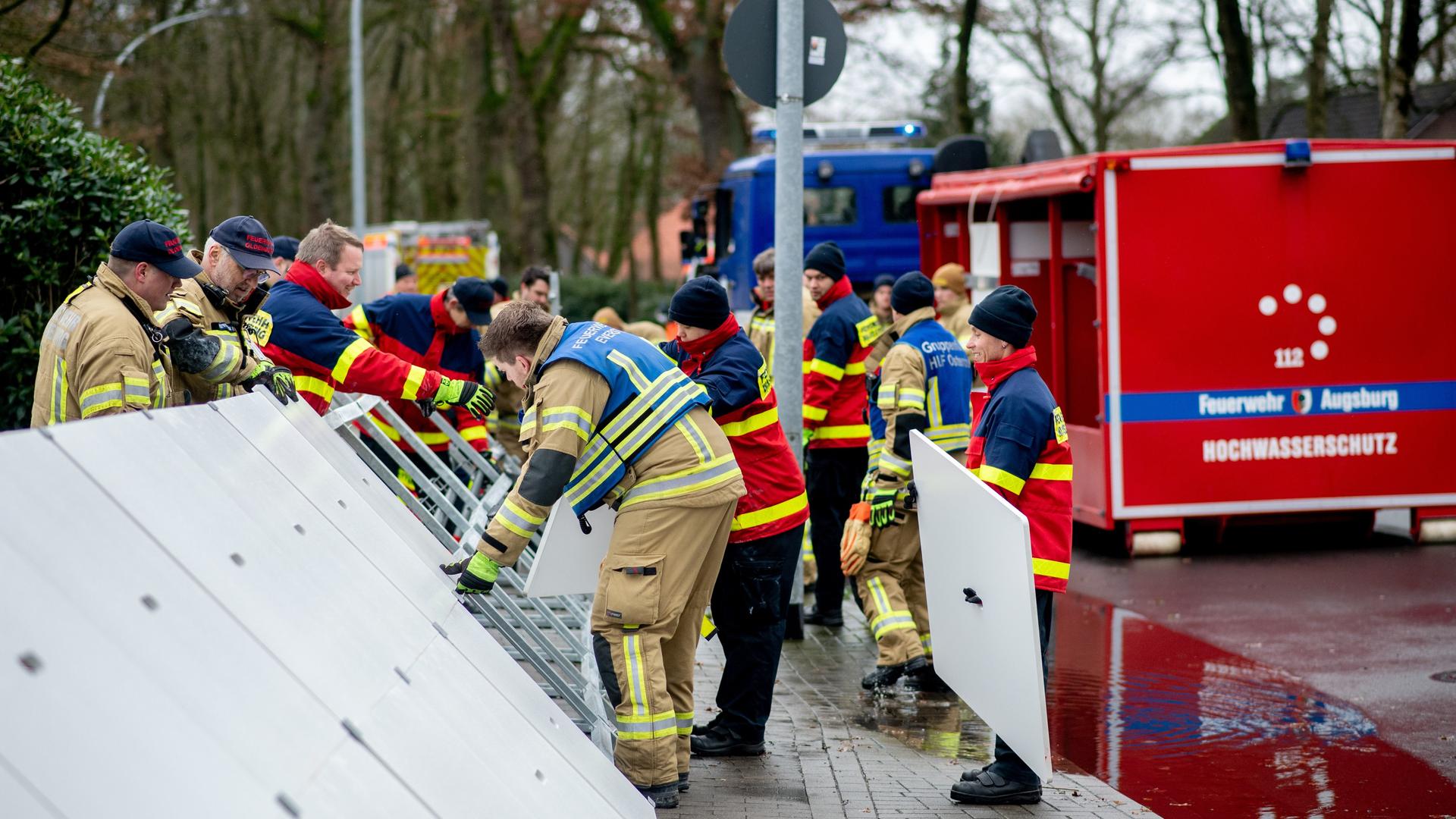 Einsatzkräfte der Feuerwehr stellen einen mobilen Deich in Oldenburg auf.