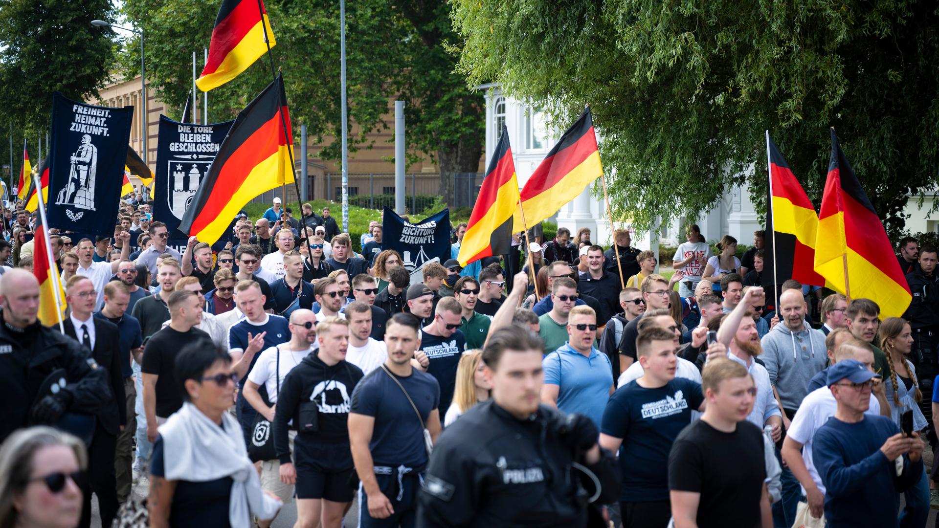 Demo-Teilnehmer der AfD-Jugendorganisation Generation Deutschland ziehen durch die Schweriner Innenstadt. Viele von ihnen tragen Deutschlandfahnen.