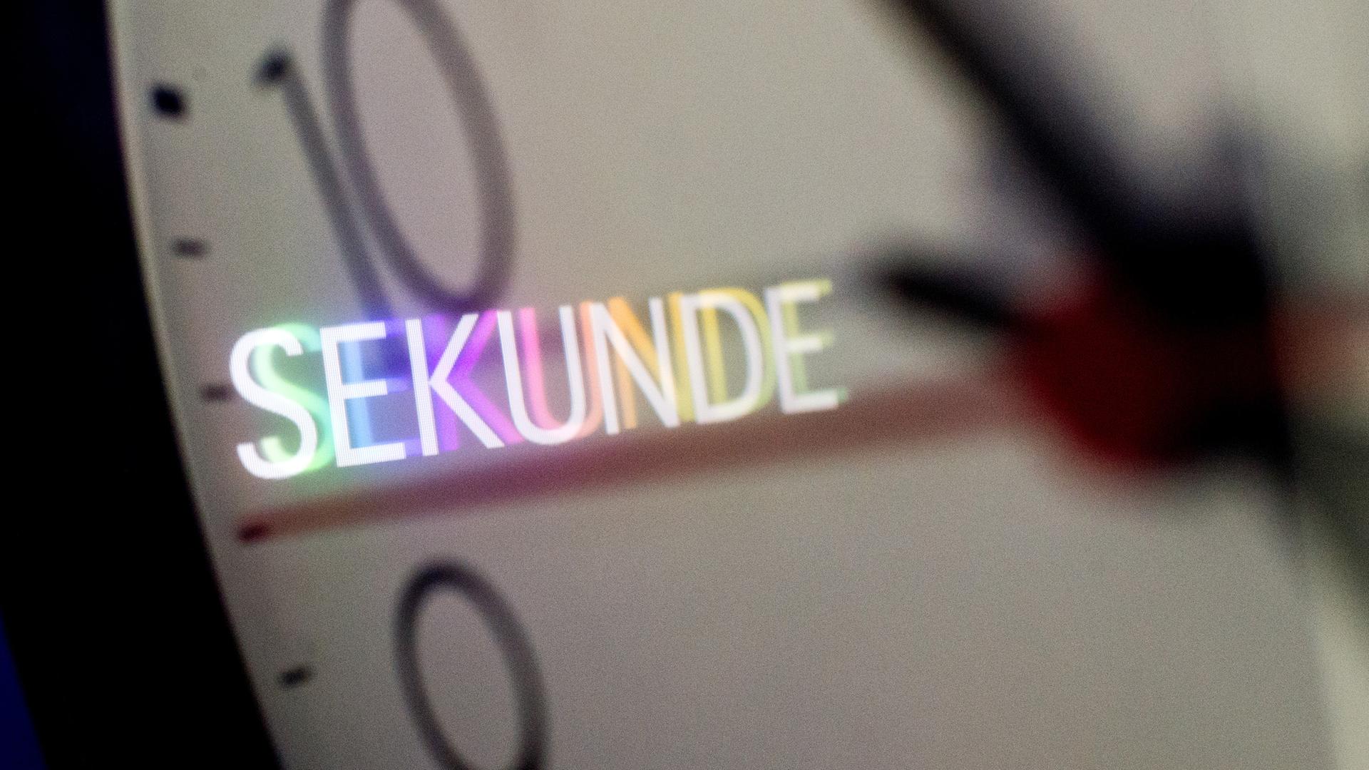 Das Wort "Sekunde" spiegelt sich am 23.06.2015 auf dem Zifferblatt einer Wanduhr in Hannover (Niedersachsen). 