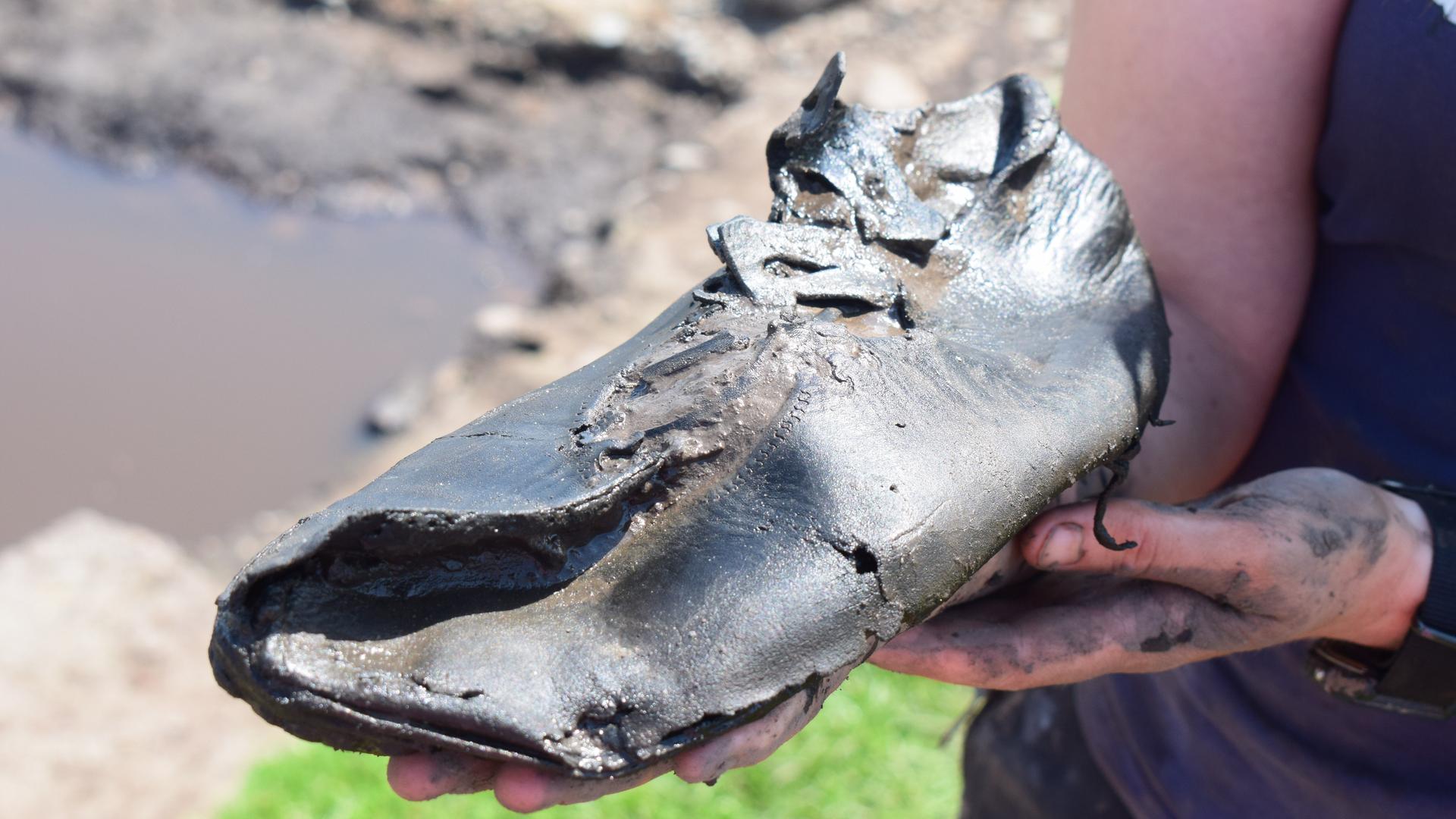 Ein alter römischer Schuh wird in die Kamera gehalten. Ein alter römischer Schuh wird in die Kamera gehalten.