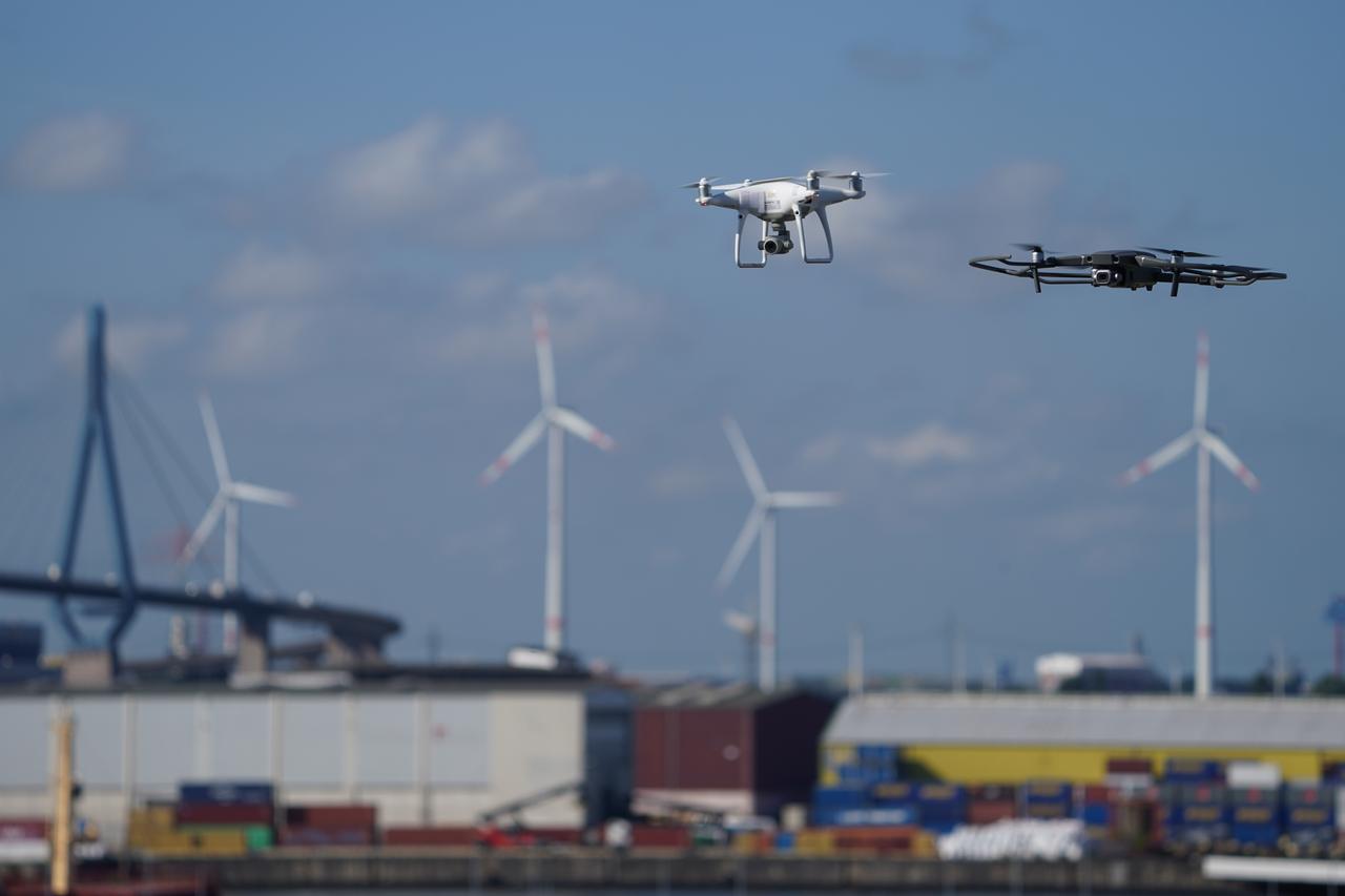Zwei Drohnen fliegen über dem Hamburger Hafen.