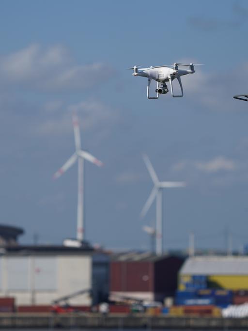 Zwei Drohnen fliegen über dem Hamburger Hafen.