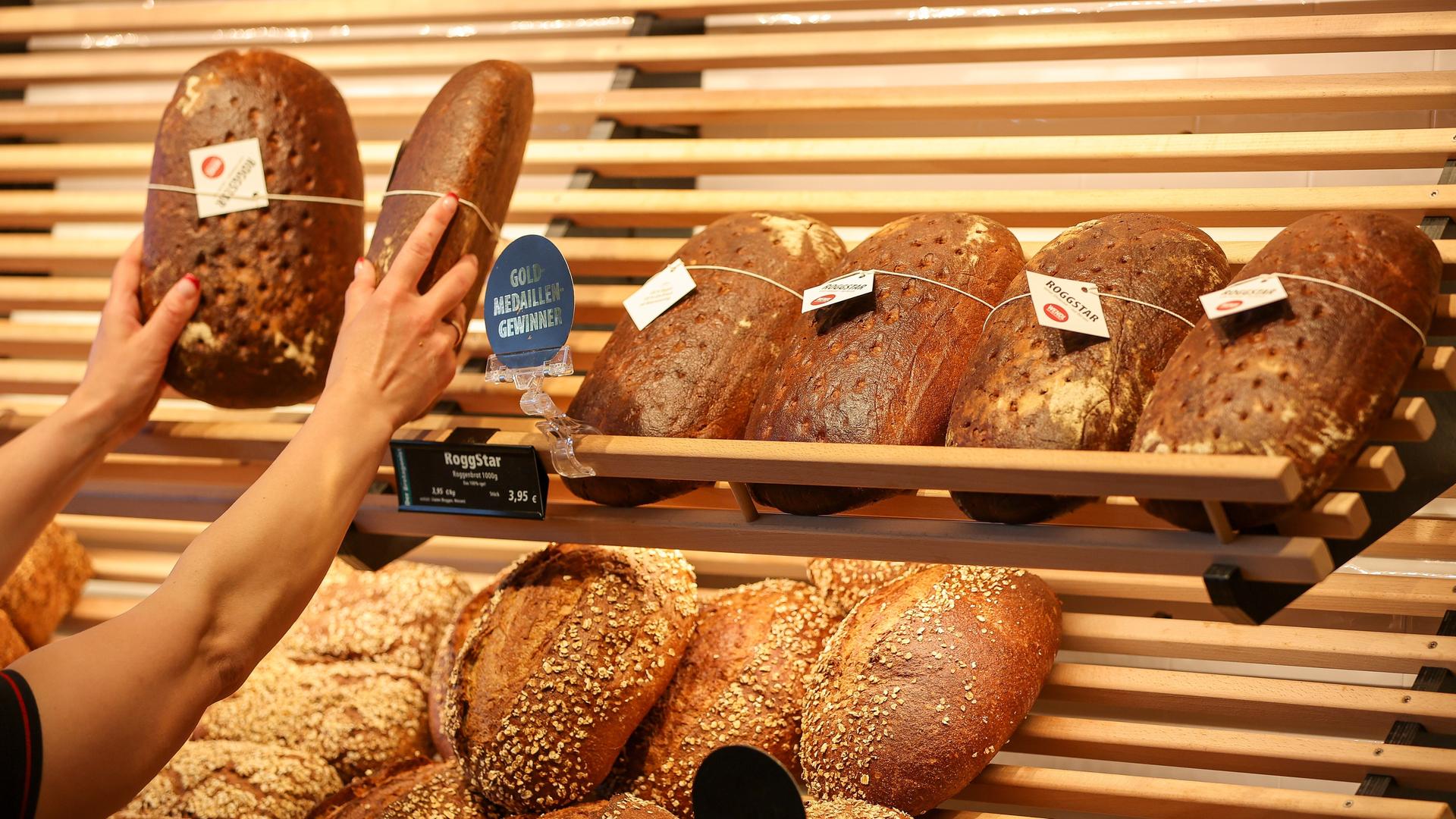 Mitarbeiterin räumt Brot in die Auslage einer Bäckerei
