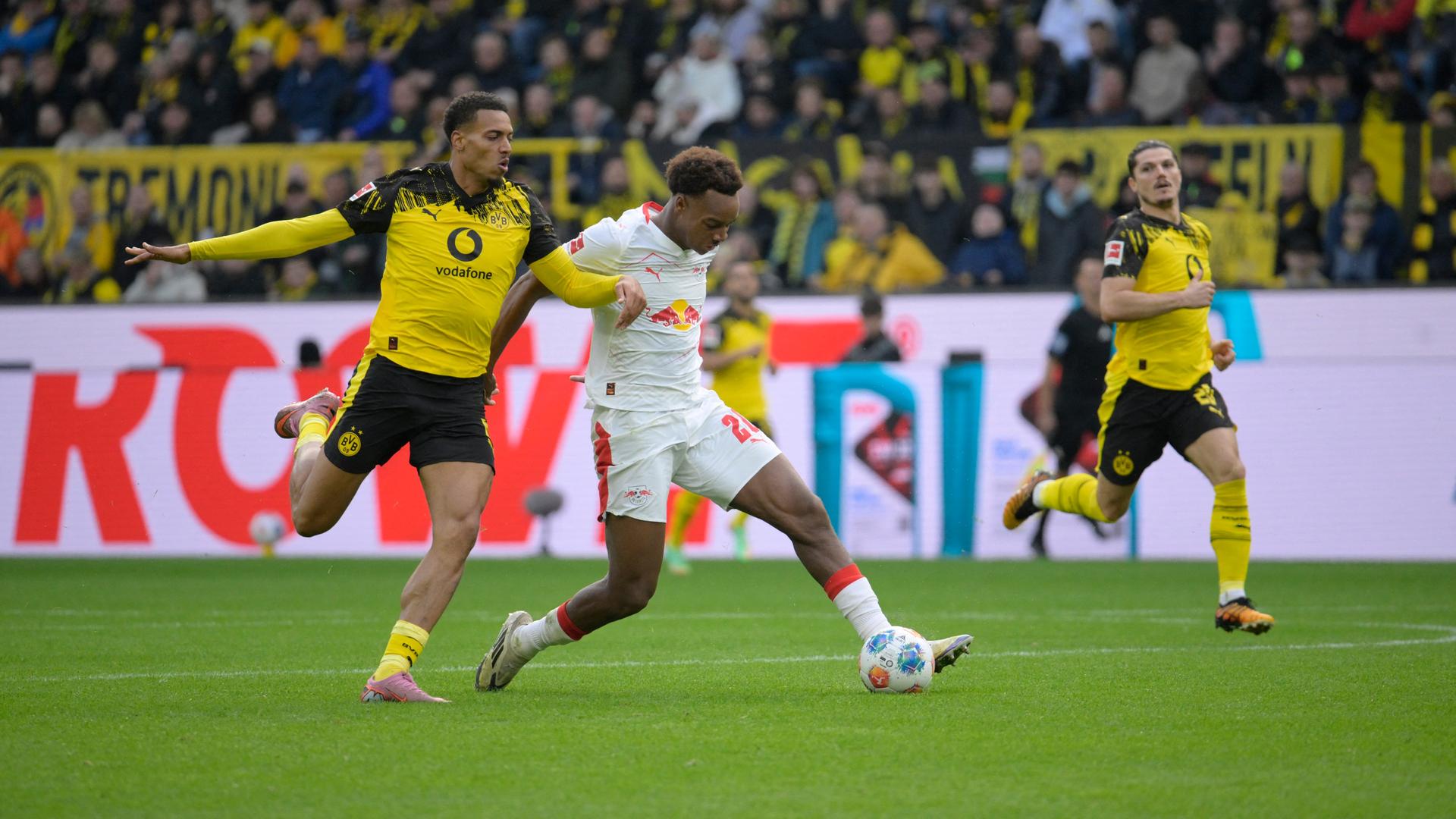 Dortmunds Spieler Felix Nmecha und der Leipziger Assan Ouedraogo kämpfen um den Ball. 