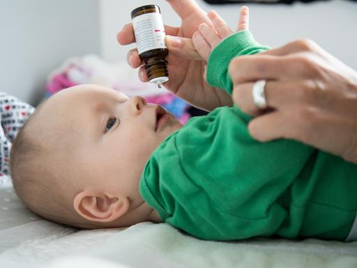 Eine Mutter verabreicht ihrem sechs Monate alten Baby Vitamin-D-Tropfen (gestellte Szene). 