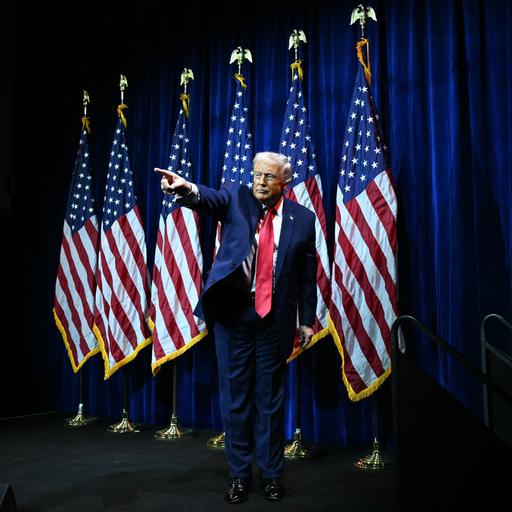 Donald Trump steht auf einer Bühne vor US-Flaggen und zeigt mit ausgestrecktem Arm und Zeigefinger ins Publikum.