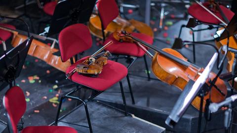 Instrumente liegen während der Probenpause eines Orchestern auf Stühlen in einem Orchestergraben.
