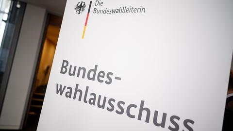 Auf einem Hinweisschild steht oben links "DIe Bundeswahlleiterin", darunter steht in Großbuchstaben "Bundeswahlausschuss".