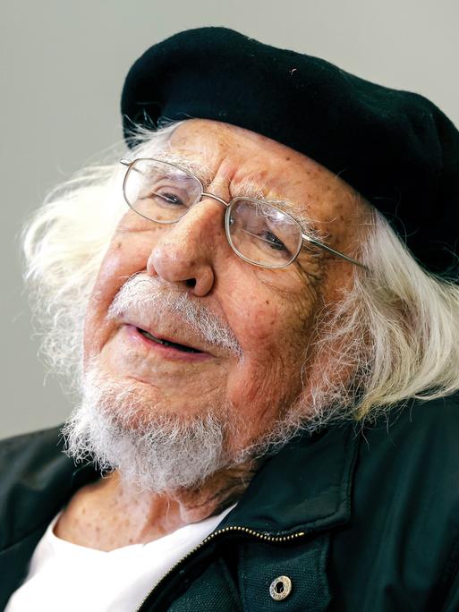 Ernesto Cardenal trägt eine Baskenmütze und lächelt in die Kamera