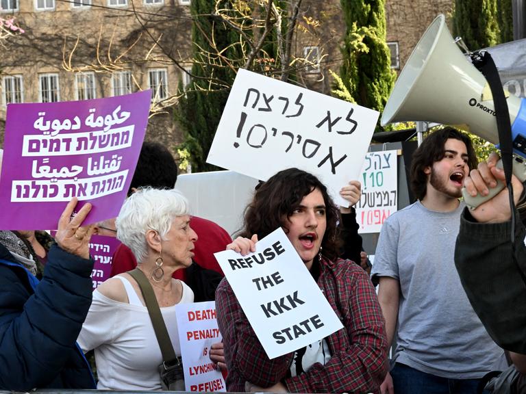 Vor der Knesset in Westjerusalem stehen einige Demonstranten, die gegen den Parlamentsbeschluss protestieren, die Todesstrrafe für verurteilte Terroristen einzuführen. 