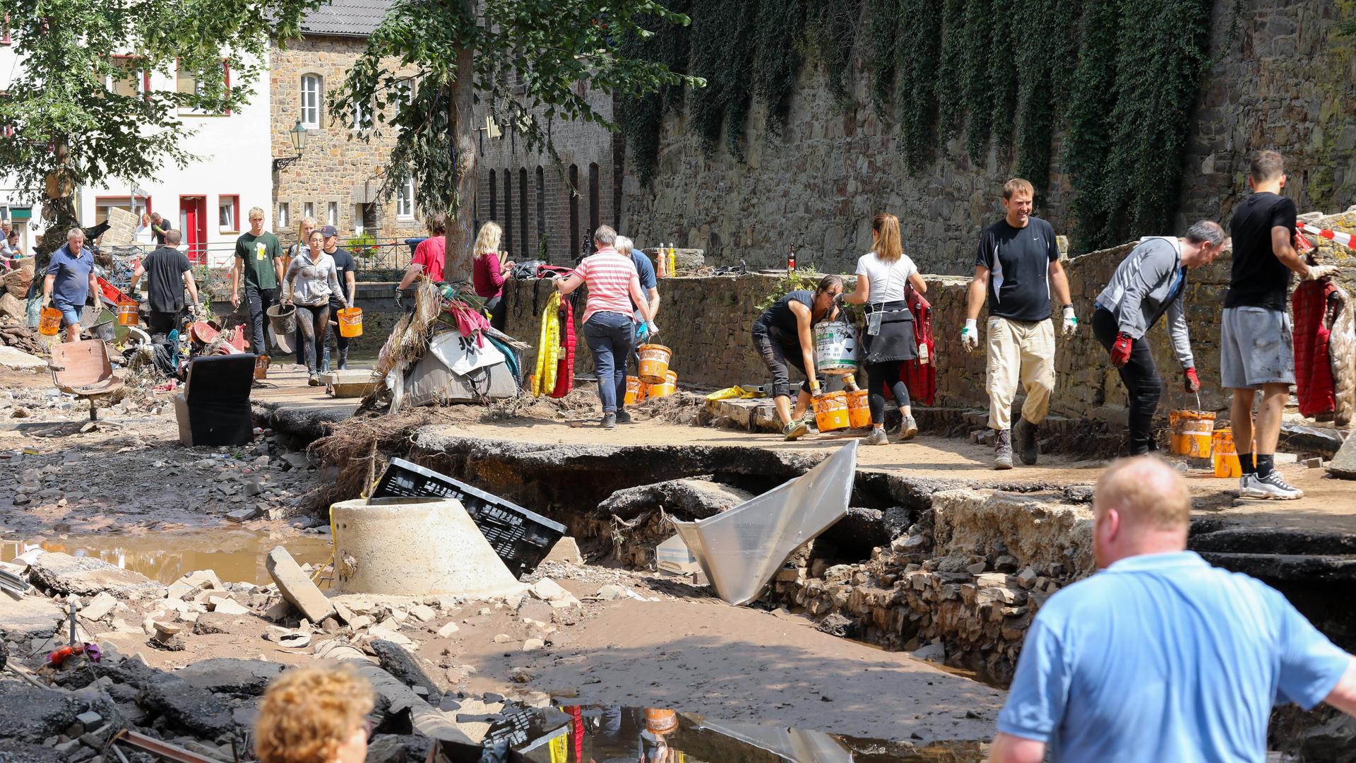 Freiwillige Helfer bei den Aufräumarbeiten in der Altstadt von Bad Münstereifel nach der Flutkatastrophe 2021.