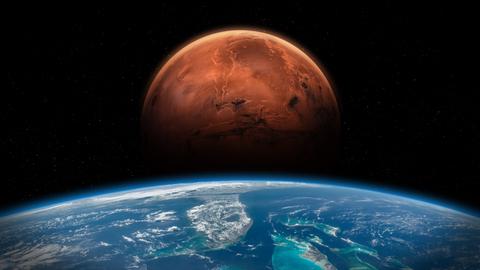 Im Vordergrund die Erde, dahinter erhebt sich der rote Mars vor schwarzem Hintergrund