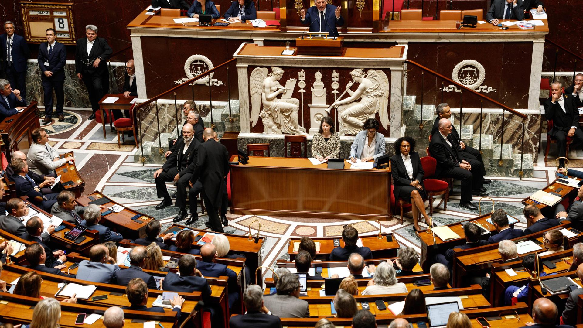 Blick ins französische Parlament, wo zahlreiche Abgeordnete in einem Halbrund sitzen. 