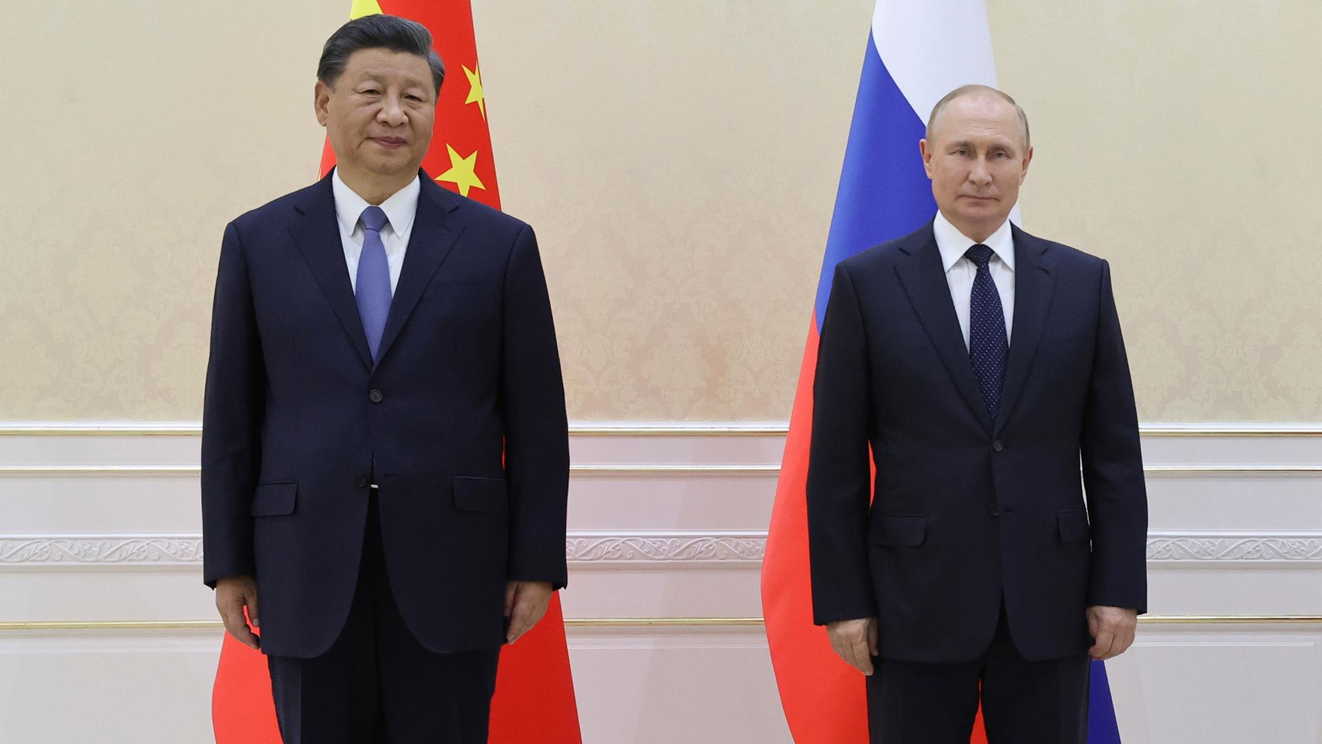 Chinas Staatschef Xi und Russlands Präsident Putin stehen vor den Fahnen ihrer Länder nebeneinander