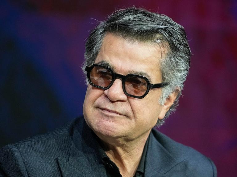 Der iranische Regisseur Jafar Panahi im Porträt mit dunkler Brille. 