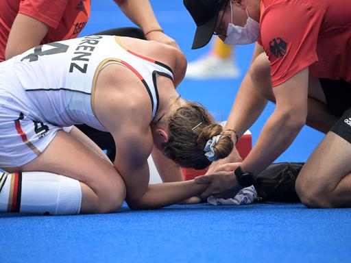 Die deutsche Hockey-Spielerin Nike Lorenz wird auf dem Feld an der Hand behandelt.