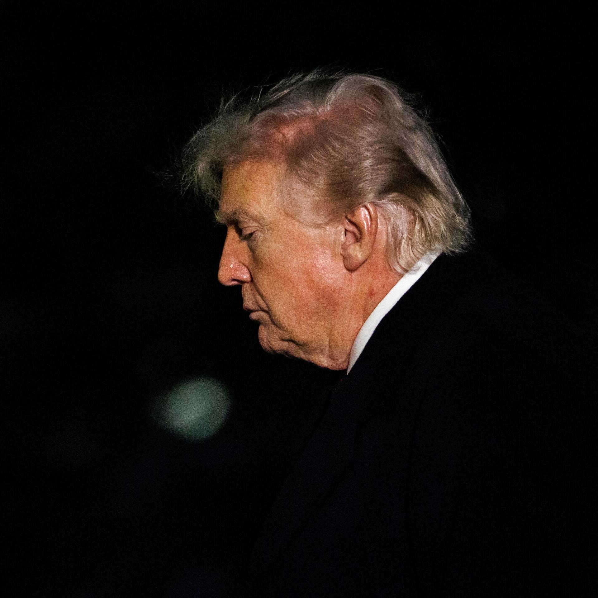 Das Foto zeigt das Gesicht von Donald Trump im Profil, als er in der Dunkelheit ins Weiße Haus in Washington zurückkehrt.