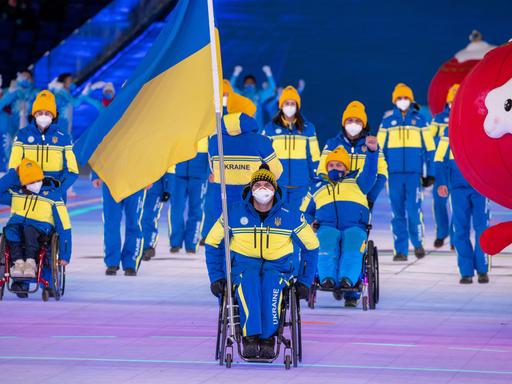 Maksym Yarovyi, Fahnenträger der Ukraine, zieht mit der Mannschaft aus der Ukraine bei der Eröffnungsfeier der Paralympics in das Stadion ein.