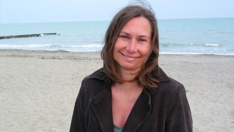 Portrait von Agnieszka Kowaluk, im Hintergrund Meer und Strand
