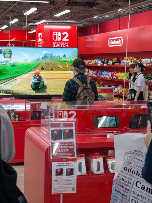 In einem Elektronikgeschäft in Japan testet ein Mann die Spielekonsole Switch Zwei.