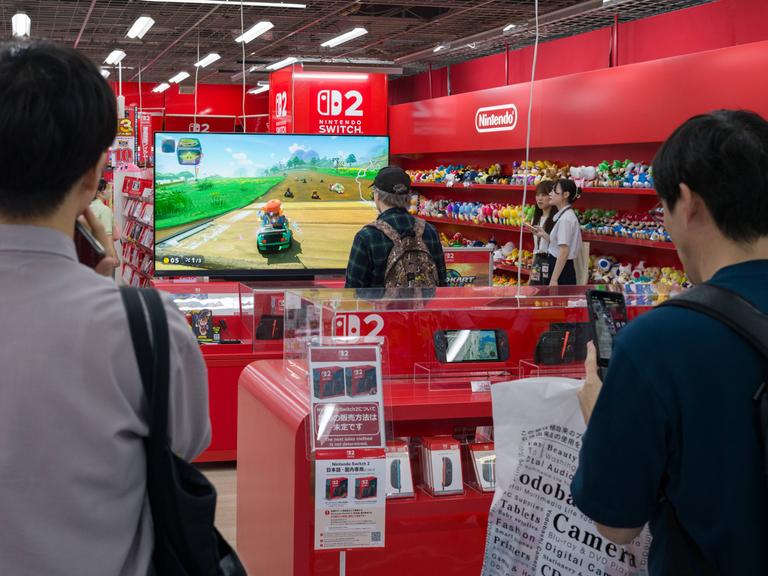 In einem Elektronikgeschäft in Japan testet ein Mann die Spielekonsole Switch Zwei.