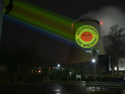 Aktivisten der Anti-Atom-Bewegung projizieren eine große Anti-Atom-Sonne auf den Kühlturm des Atomkraftwerkes Emsland. 